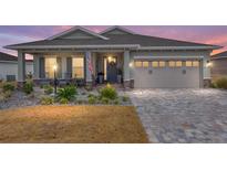 Single-story home with gray exterior, paver driveway, and landscaped yard at 10339 Sw 96Th Ln, Ocala, FL 34481