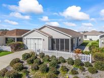 Single-story home with screened porch, white picket fence, and landscaped yard at 1817 Hallandale Ln, The Villages, FL 32162