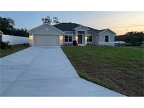 Charming single-story home featuring a well-manicured lawn and attached two-car garage at 77 Olive Dr, Ocala, FL 34472