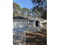 One-story home with attached garage, landscaping, and a welcoming front entrance at 7795 Sw 181St Cir, Dunnellon, FL 34432