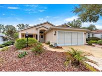 Single-story house with landscaped yard, driveway, and two-car garage at 9176 Sw 93Rd Cir, Ocala, FL 34481