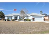 One-story house with attached garage, manicured lawn, and American flag at 9688 Sw 45Th Ave, Ocala, FL 34476