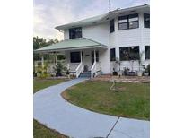 Exterior front view of the home with a sidewalk and a white porch with gray stairs at 10245 Sw 105Th St, Ocala, FL 34481