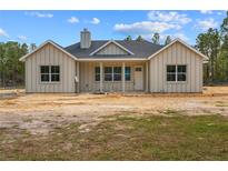 New construction with board and batten exterior, gray roof, and covered porch at 11910 Sw 43Rd Street Road, Ocala, FL 34481