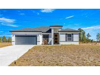 White house with gray garage door and yellow front door at 15413 Sw 65Th Terrace Rd, Ocala, FL 34473