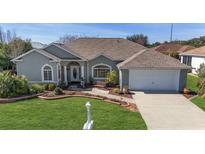 Single-story house with a two-car garage, landscaping, and a walkway at 2330 Nw 59Th Ave, Ocala, FL 34482