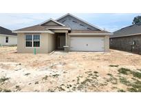Charming single-Gathering home featuring an attached two-car garage and a well-maintained lawn at 4373 Sw 90Th Pl, Ocala, FL 34476