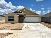 Inviting single-story home featuring a two-car garage, neutral paint, and a well-manicured lawn at 4373 Sw 90Th Pl, Ocala, FL 34476