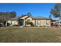 Charming one-story home featuring a well-manicured lawn and inviting landscaping at 10870 Sw 47Th Ct, Ocala, FL 34476