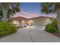 Single-story home with a red tile roof and a large driveway at 11159 Sw 68Th Ct, Ocala, FL 34476