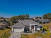 Aerial view of single-story house with gray roof and landscaped yard at 11545 Se 175Th St, Summerfield, FL 34491