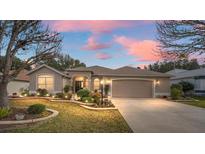 Attractive single-story home with landscaped yard and two-car garage at 1397 Oak Forest Dr, The Villages, FL 32162