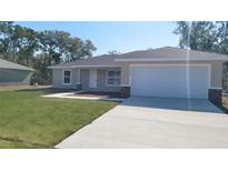 Charming single-story home featuring a two-car garage and well-manicured lawn at 17682 Sw 113Th Pl, Dunnellon, FL 34432