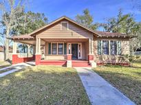 Charming bungalow with a red front porch and mature trees at 309 Ne Sanchez Ave, Ocala, FL 34470