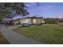 Single-story home with two-car garage, manicured lawn, and a paved driveway at 6767 Sw 91St Cir, Ocala, FL 34481