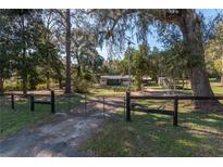 Gated property with a long driveway, lush trees and foliage provides privacy at 9352 Ne 27Th Ter, Anthony, FL 32617