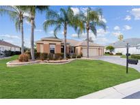 Well-manicured lawn and landscaping accentuate this lovely single-story home with a paver driveway at 9651 Se 137Th Street Rd, Summerfield, FL 34491