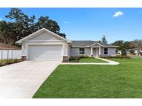 Newly constructed home with a landscaped lawn and attached garage at 1302 Ne 22Nd Ave, Ocala, FL 34470