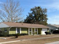 Green house with white trim, brown roof, and a two-car garage at 15083 Sw 43Rd Terrace Rd, Ocala, FL 34473