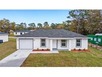 Newly built home with a gray roof and landscaped lawn at 15482 Sw 10 Pl, Ocala, FL 34481