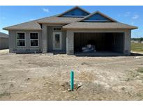 Charming single-story home with a covered entrance and an attached two-car garage awaiting landscaping at 3212 Ne 46Th Ave, Ocala, FL 34470