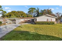 Ranch style home with carport and mature landscaping at 438 Spring Ln, Ocala, FL 34472