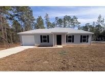Newly constructed single-story home with a landscaped yard at 67 Nw Sparrow Rd, Dunnellon, FL 34431