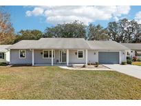 Charming single-story home featuring a well-maintained lawn, attached garage, and cozy covered front porch at 1517 New Abbey Ave, Leesburg, FL 34788