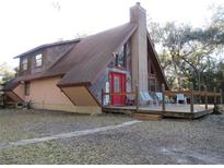 A-frame house with wood siding, deck, and large windows at 17840 Se 28Th Pl, Silver Springs, FL 34488