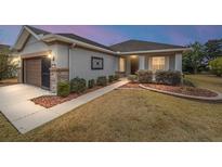 One-story home with brown garage door, landscaping, and walkway at 7454 Sw 101St Ave, Ocala, FL 34481