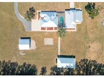 Stunning aerial view of a unique estate with a screened pool and multiple outbuildings at 7688 Se 135Th St, Summerfield, FL 34491