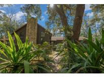 A charming one-story home nestled among lush landscaping, featuring a stone chimney at 7740 Sw 70Th Ave, Ocala, FL 34476