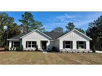 Charming single-story home featuring a well-manicured lawn, stone accents, and a welcoming entrance at 8481 Sw 137 Ct, Dunnellon, FL 34432