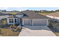 Beautiful home with stone accents, manicured lawn, and a two-car garage on a sunny day at 8630 Sw 61St Loop, Ocala, FL 34481