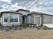 Beautiful single-story home with a stone-accented, three-car garage and well-maintained landscaping at 8630 Sw 61St Loop, Ocala, FL 34481