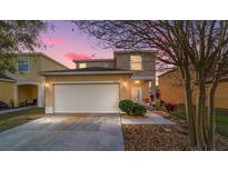 Charming two-story home with a two car garage, beautiful landscaping, and a walkway to the front door at 12312 Ne 48Th Loop, Oxford, FL 34484