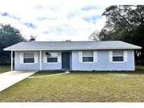 Charming single story home with blue exterior, white trim and a well-maintained front yard at 1904 Ne 50Th St, Ocala, FL 34479