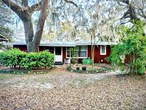 Charming single-story home featuring lush landscaping and mature trees draped with Spanish moss at 19390 Se 95Th Pl, Ocklawaha, FL 32179
