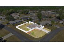 Charming single-story home with white fence, well-manicured lawn, and long driveway on a spacious lot at 2 Hemlock Terrace Trl, Ocala, FL 34472