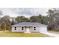 Charming single-story home with neutral paint, gray roof, attached garage and tidy landscaping at 24264 Sw South Hills Ct, Dunnellon, FL 34431