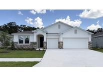 Charming single-story home featuring stone accents, a two-car garage and a well-manicured lawn at 3079 Canopy Oak Blvd, Wildwood, FL 34785