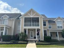 Charming two-story home with a covered porch, manicured landscaping, and a welcoming walkway at 130 Harbour Cove Way, Clermont, FL 34711