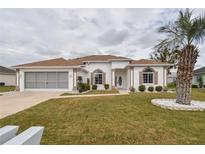 Charming home featuring a well-manicured lawn, two-car garage and attractive landscaping at 2209 Nw 55Th Avenue Rd, Ocala, FL 34482