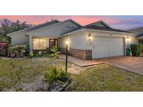 Charming single-story home with brick-lined driveway, integrated garage, manicured landscaping, and inviting curb appeal at 9133 Sw 91St Cir, Ocala, FL 34481