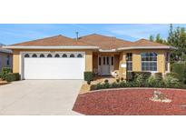 Charming single-story home with a well-maintained lawn, a two-car garage, and colorful rock landscaping at 10003 Sw 90Th Loop, Ocala, FL 34481