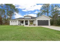 Charming single-story home with a well-manicured lawn, gray garage door, and lovely curb appeal at 13105 Sw 73Rd Avenue Rd, Ocala, FL 34473