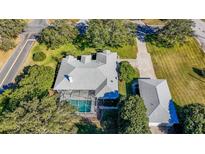 Aerial view of the home featuring a screened-in pool and well-maintained landscaping at 1712 Ne 40Th Ave, Ocala, FL 34470