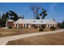 Charming brick home with dormer windows, mature landscaping, and a circular driveway at 3560 Sw 24Th Avenue Rd, Ocala, FL 34471