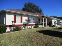 Charming single-story home with a well-maintained lawn and colorful accents on the shutters and trim at 11353 Sw 138Th Ln, Dunnellon, FL 34432