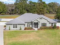 Charming single-story home featuring a well-manicured lawn, tasteful landscaping, and a welcoming entrance at 5297 Se 39 Loop, Ocala, FL 34480